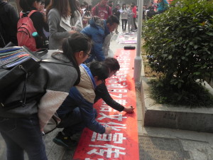 Chinese students sign a petition against corruption